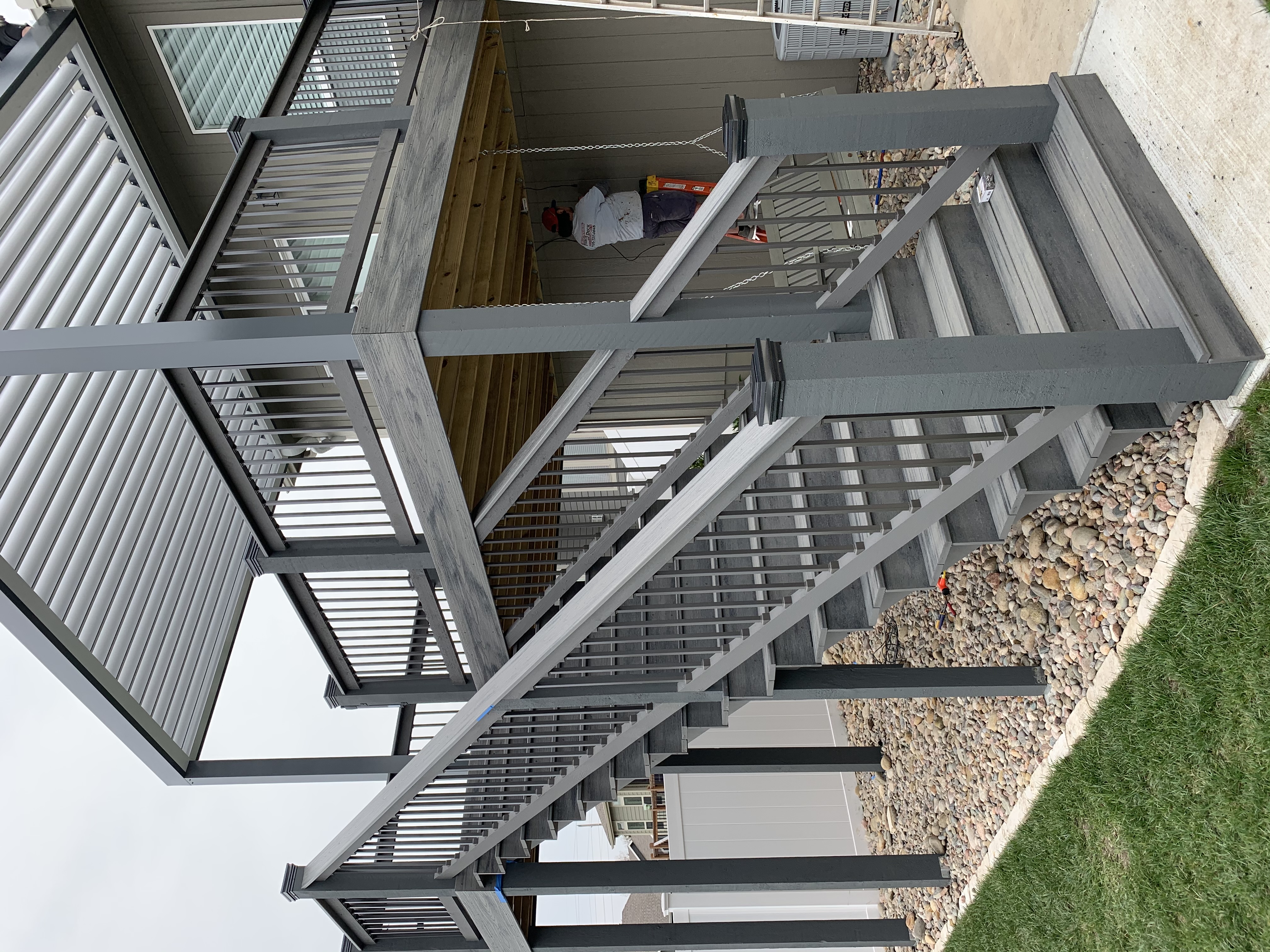 gray deck with stairs gravel and pergola