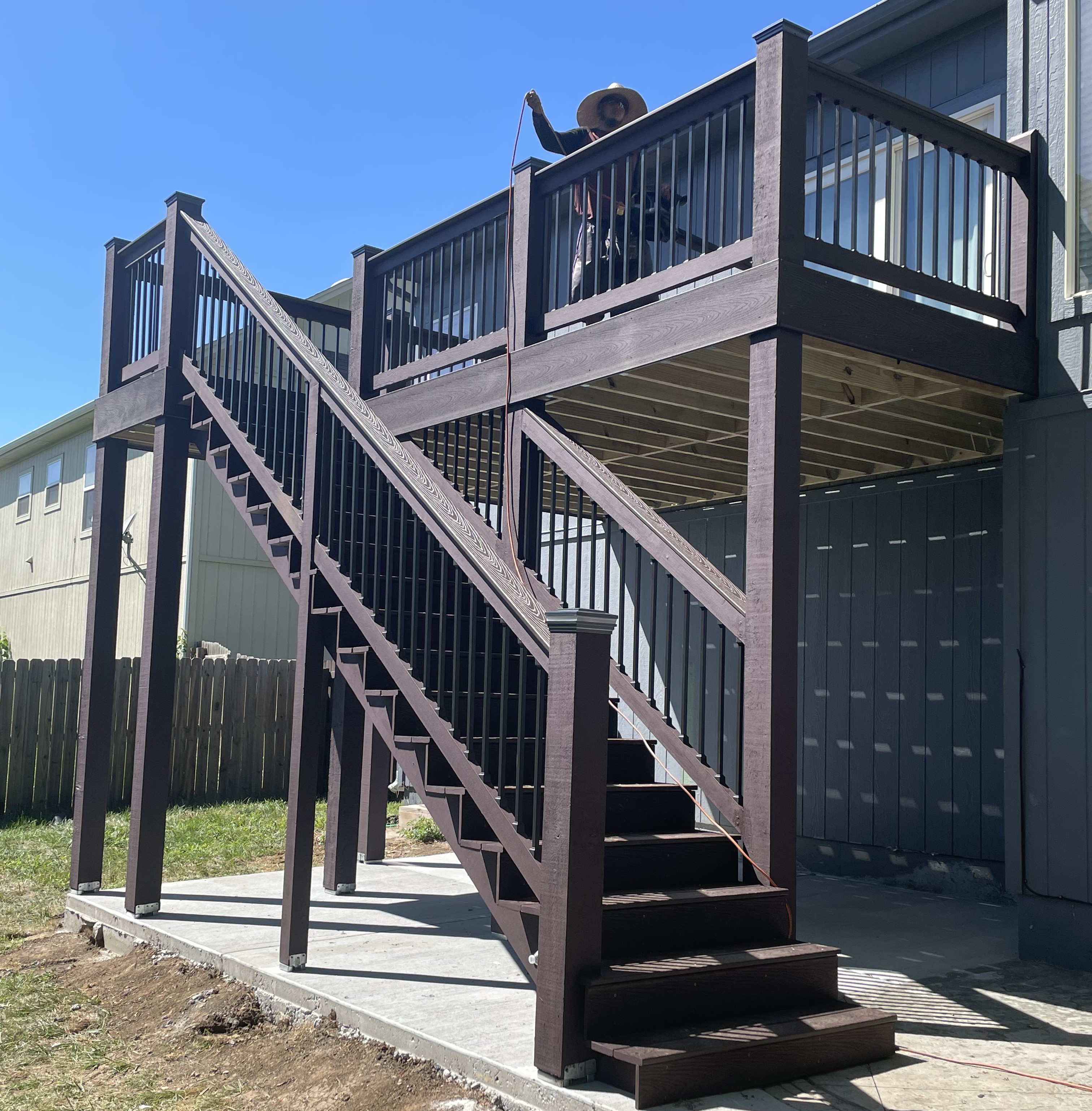 brown deck with stairs and no roof over a concrete slab