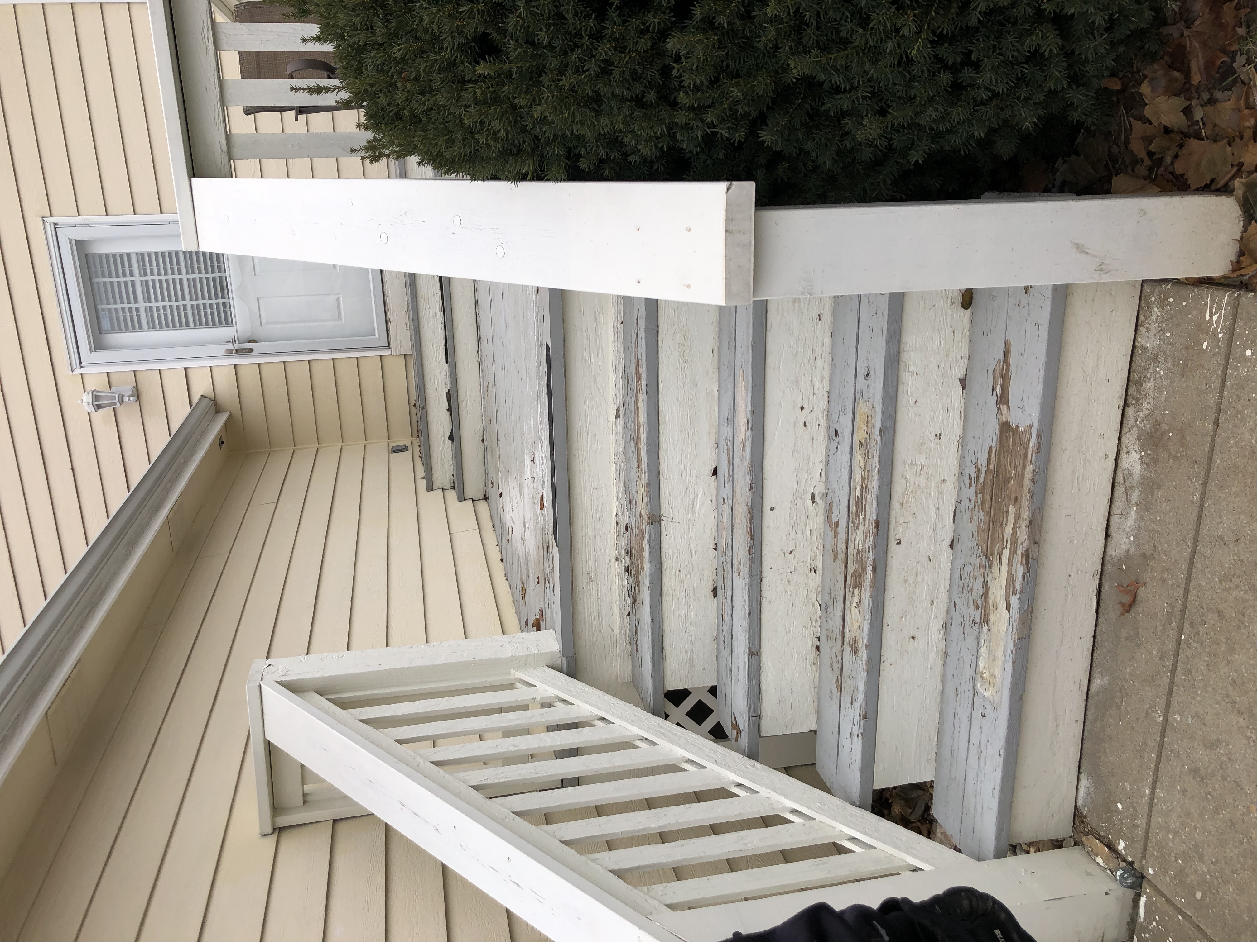 white and blue porch deck with paint fading on the floor stairs and railing