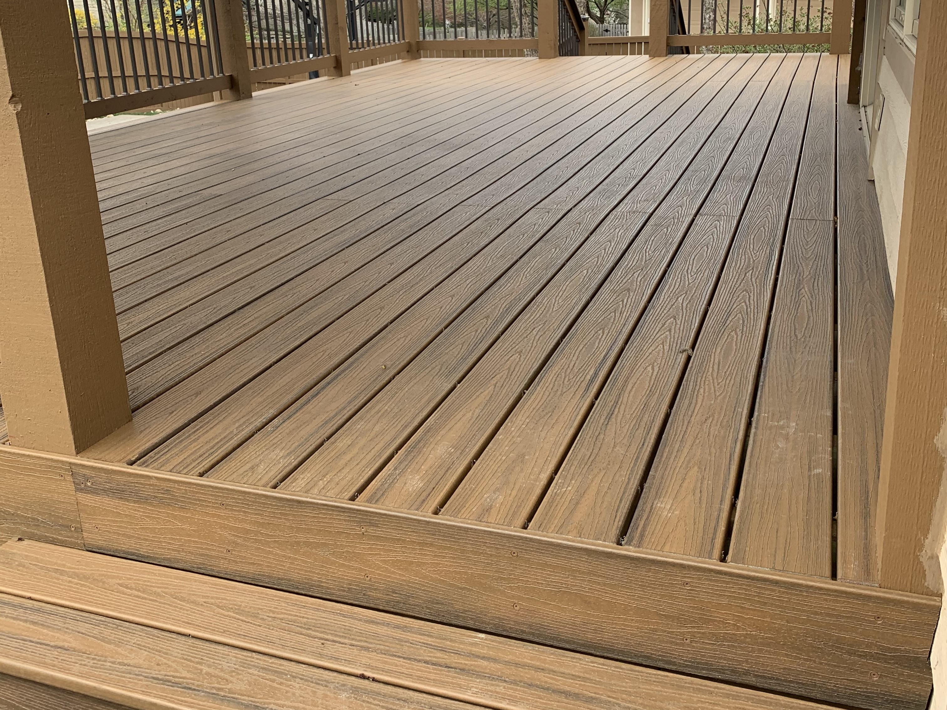 light brown deck floor with brown railing and steps