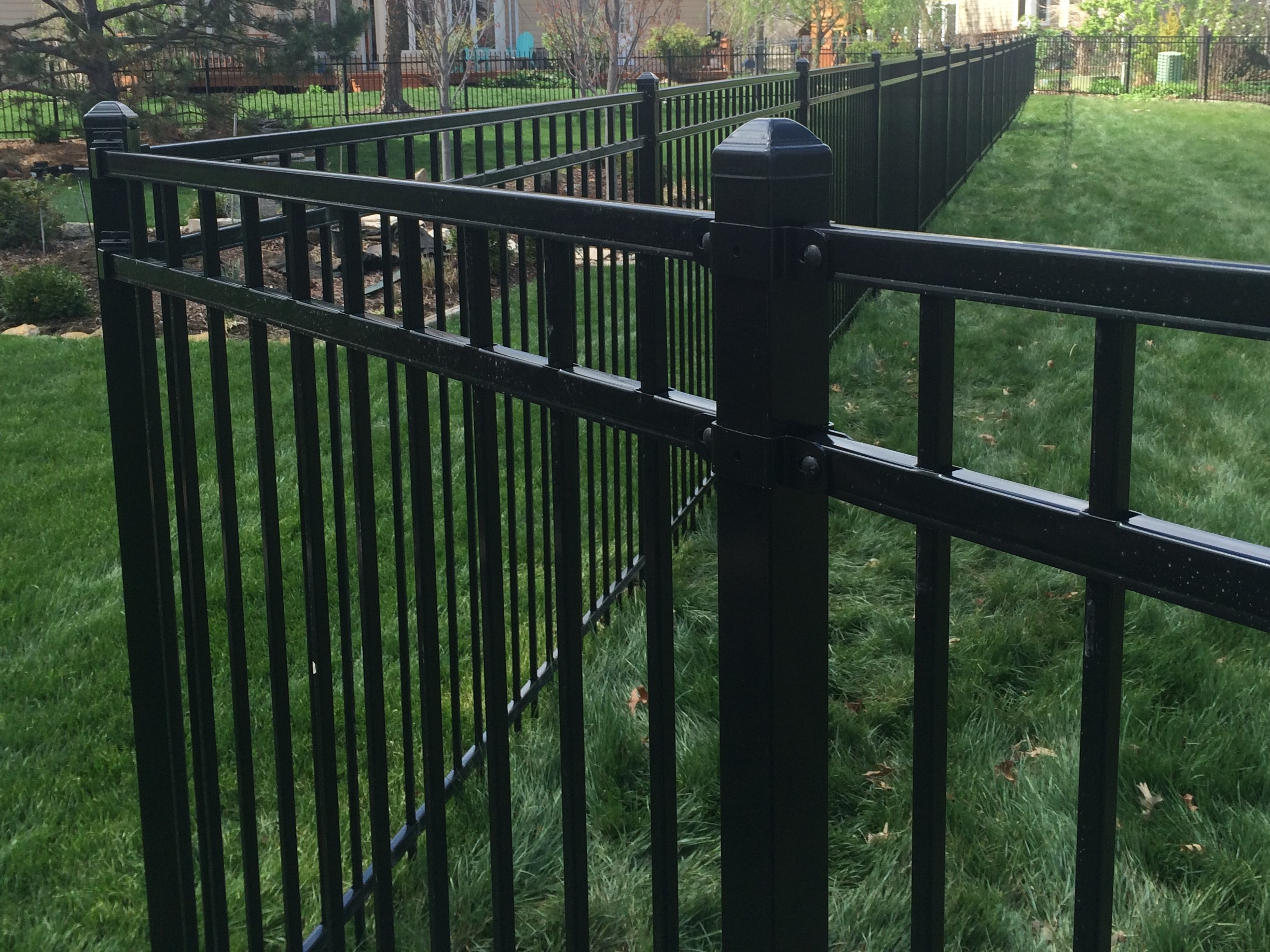 steel fence showing how straight it is for at least 40 feet along a backyard