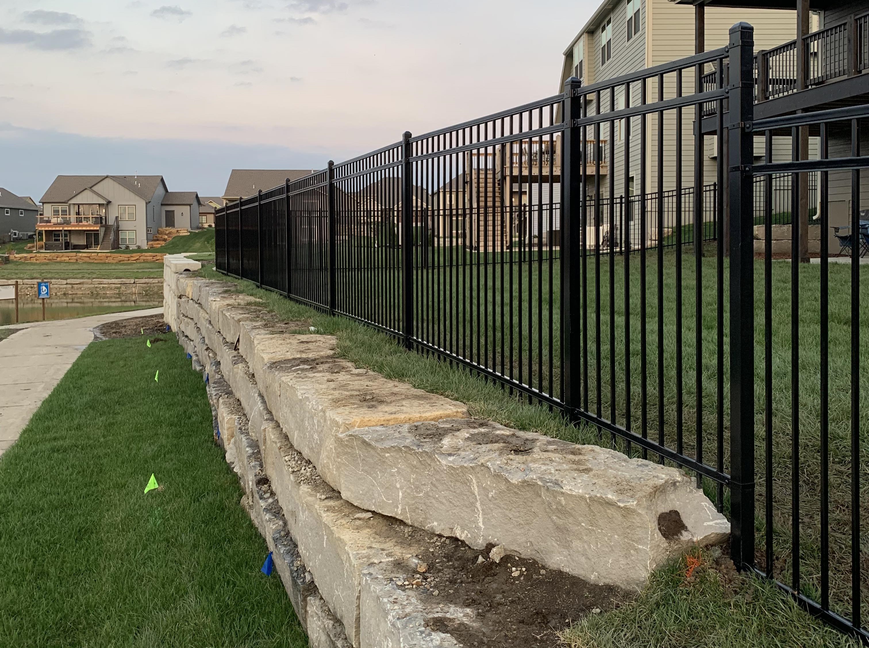 tall steel fence over a retaining wall