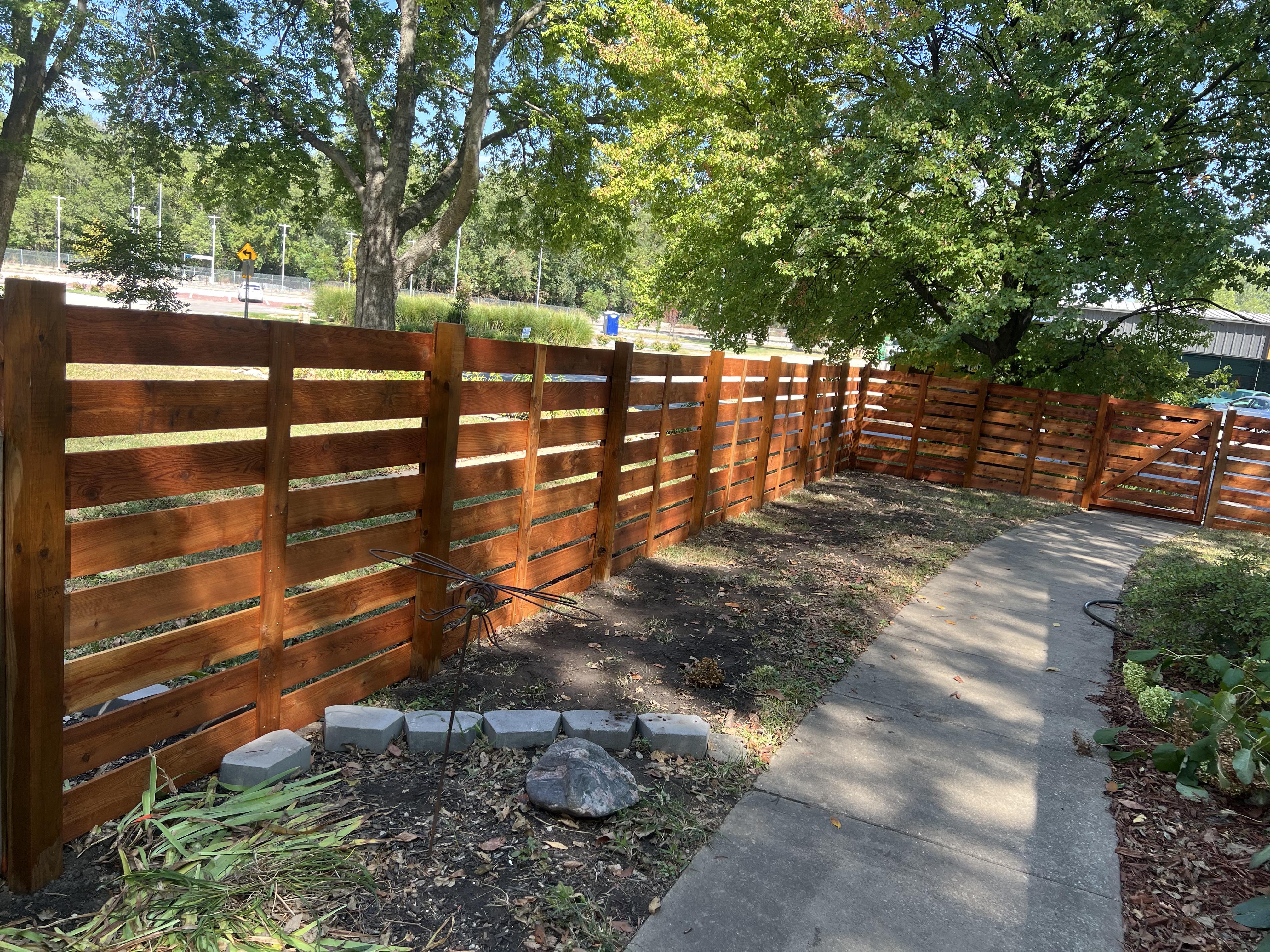 stained wood fence with a horizontal fence style that is 4 foot tall