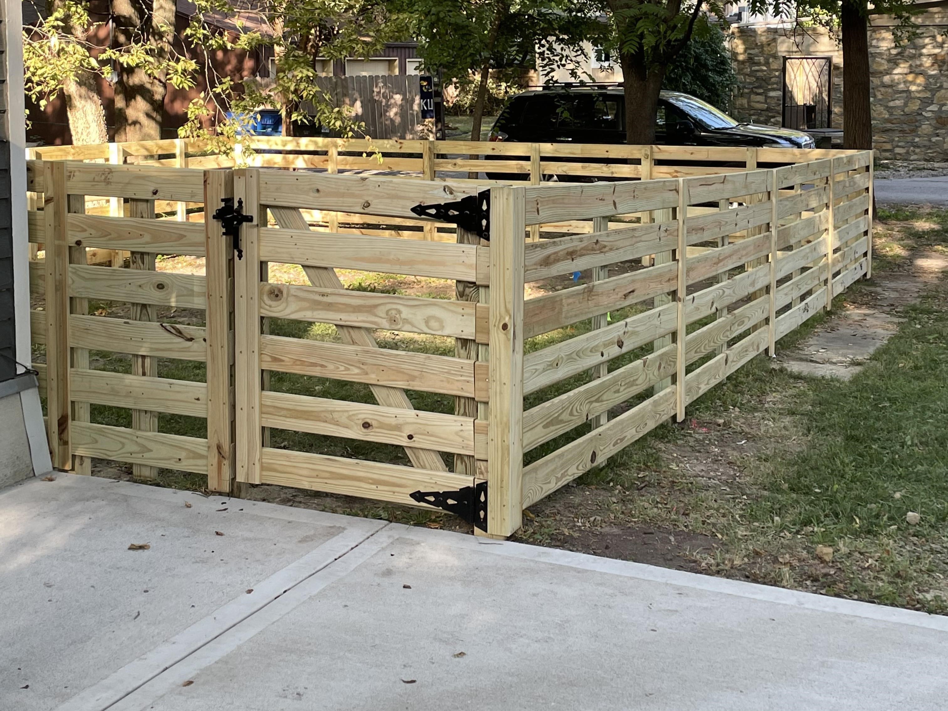 wood horizontal fence that is protecting a yard and is 4 foot tall