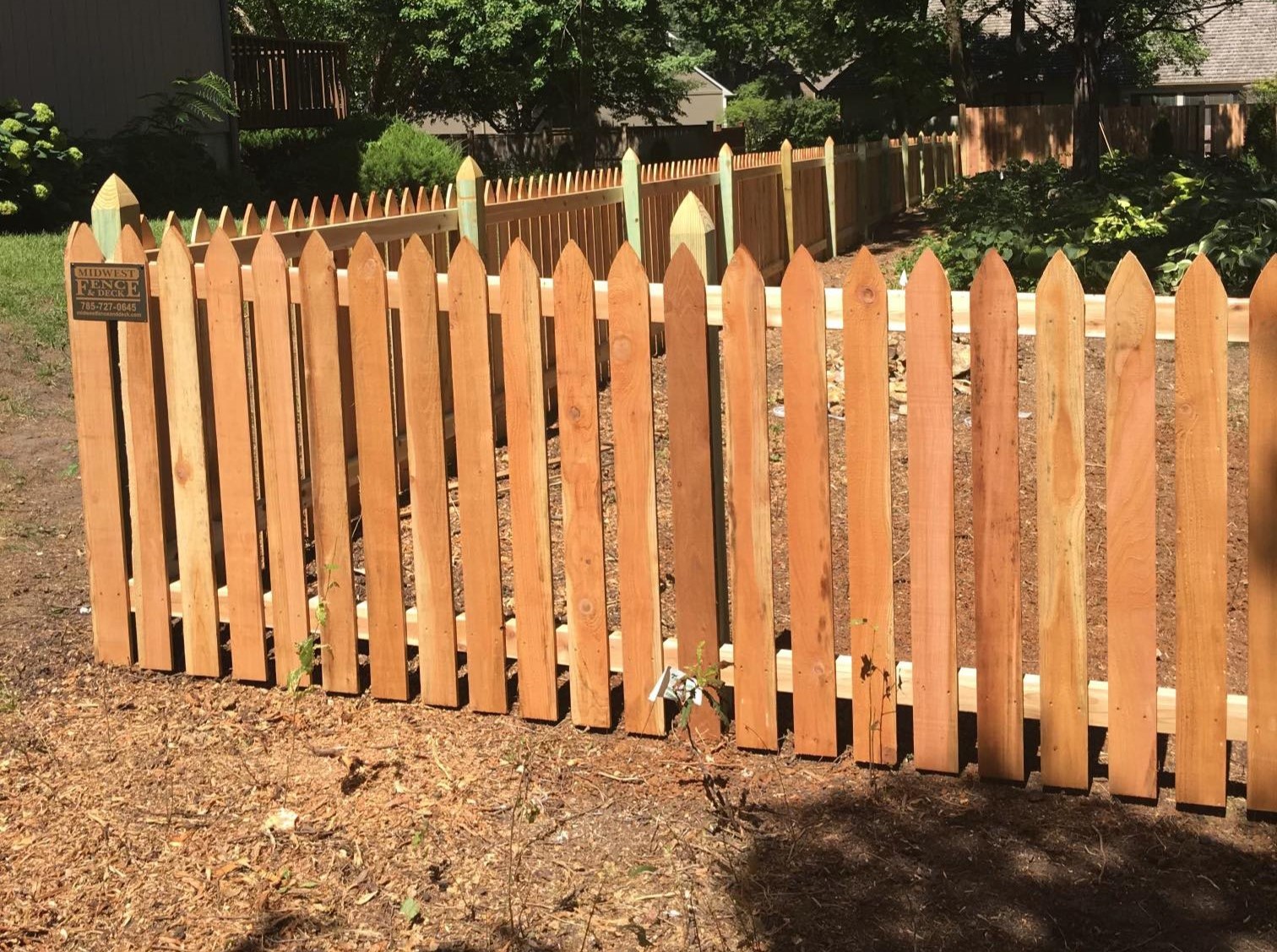 wood picket fence going up hill while remaining straight