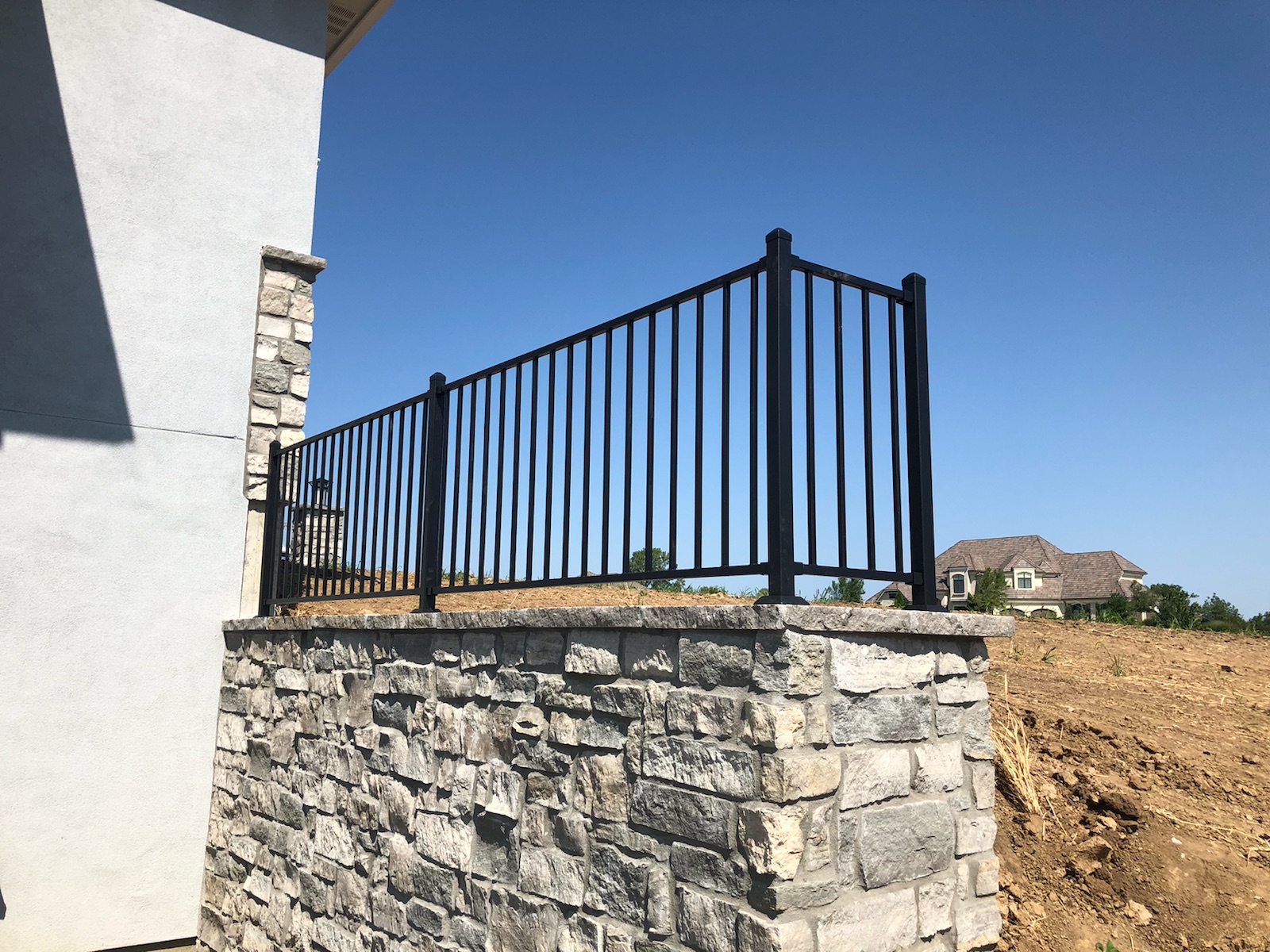 stone retaining wall with steel railing on top