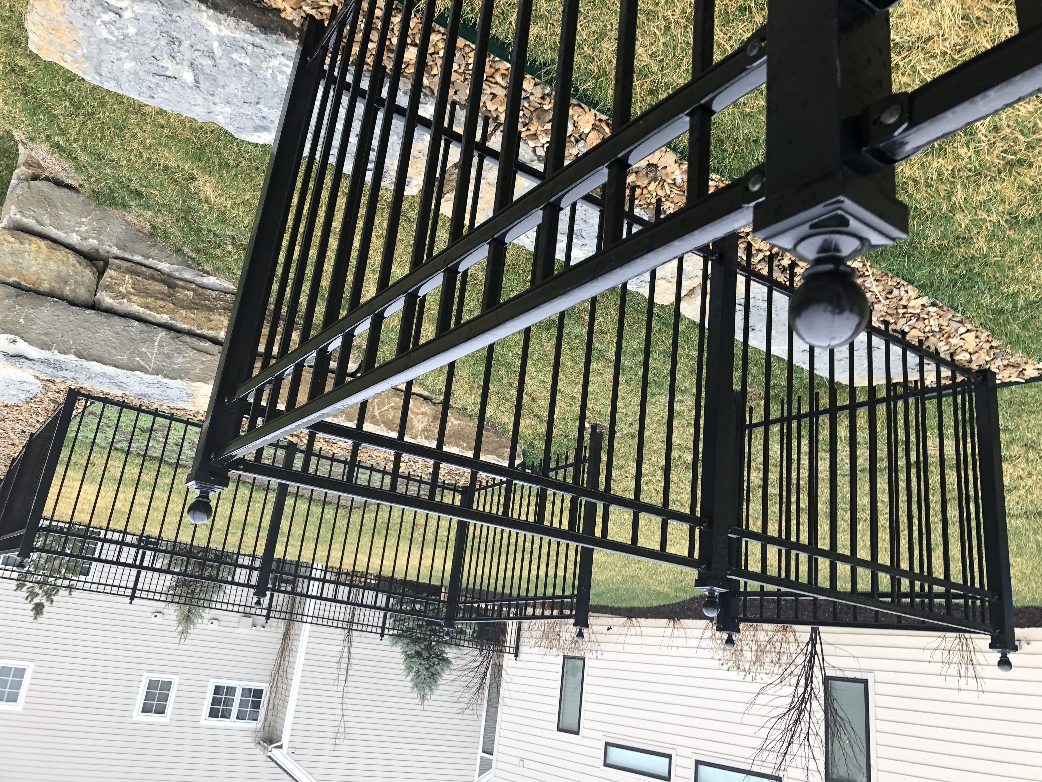 steel fence  with multiple corners over retaining wall