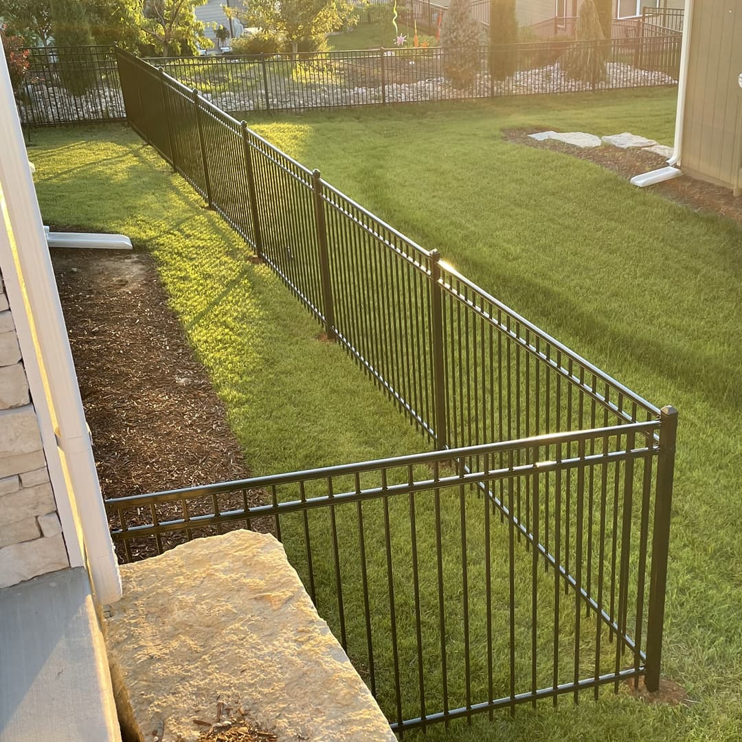 Straight steel fence with the setting sun in the background